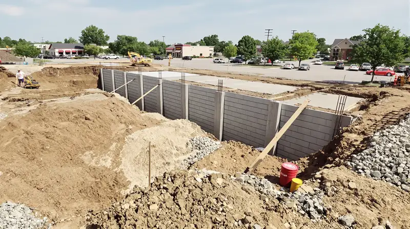 Full-scope commercial construction showing excavation, foundation, and finished concrete at a Kansas City site — Ford Concrete